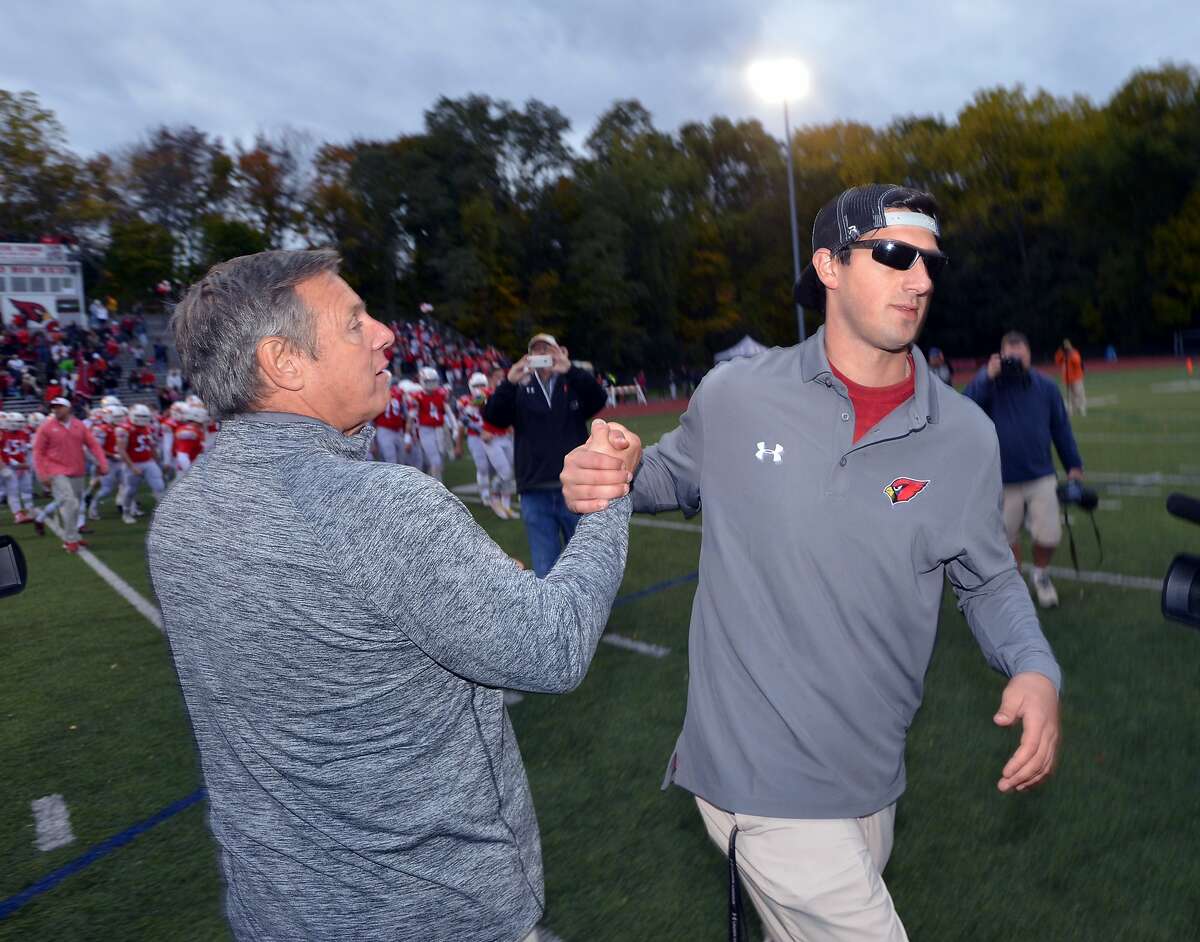 At right, Greenwich High School head football coach John Marinelli, shakes hands with his father, Lou Marinelli, just after losing to his father's New Canaan High School football team by a score of 24-14 at Greenwich, Conn., Saturday, Oct. 24, 2015. Lou Marinelli is the head coach of the New Canaan High School football team.