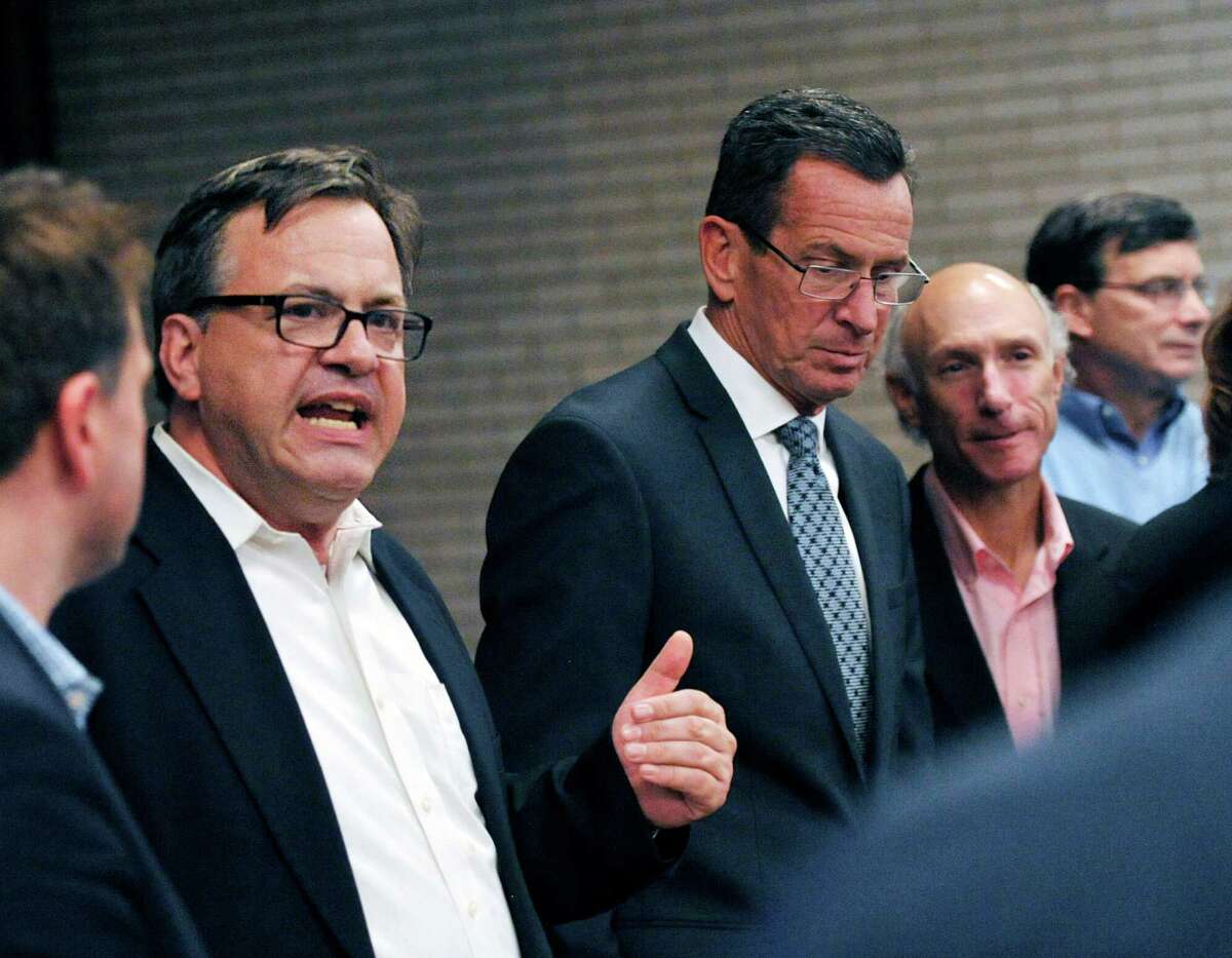 Democratic candidate for Greenwich First Selectman Frank Farricker, left, speaks as Gov. Dannel P. Malloy, third from right, listens during a campaign appearance by Gov. Malloy to support the Greenwich Democrats for the upcoming election at the Central Greenwich Train Station, Wednesday night, Oct. 28, 2015. Second from right is Howard Richman the Democratic candidate for Greenwich tax collector.