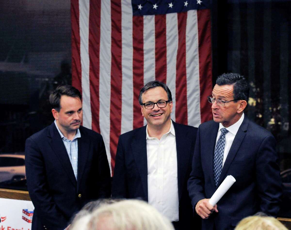 Gov. Dannel P. Malloy, right, campaigns for Greenwich Democrats, Drew Marzullo, left, for selectman and Frank Farricker, center, for first selectman during a campaign stop by Gov. Malloy for the upcoming local Greenwich election, at the Central Greenwich Train Station, Wednesday night, Oct. 28, 2015.