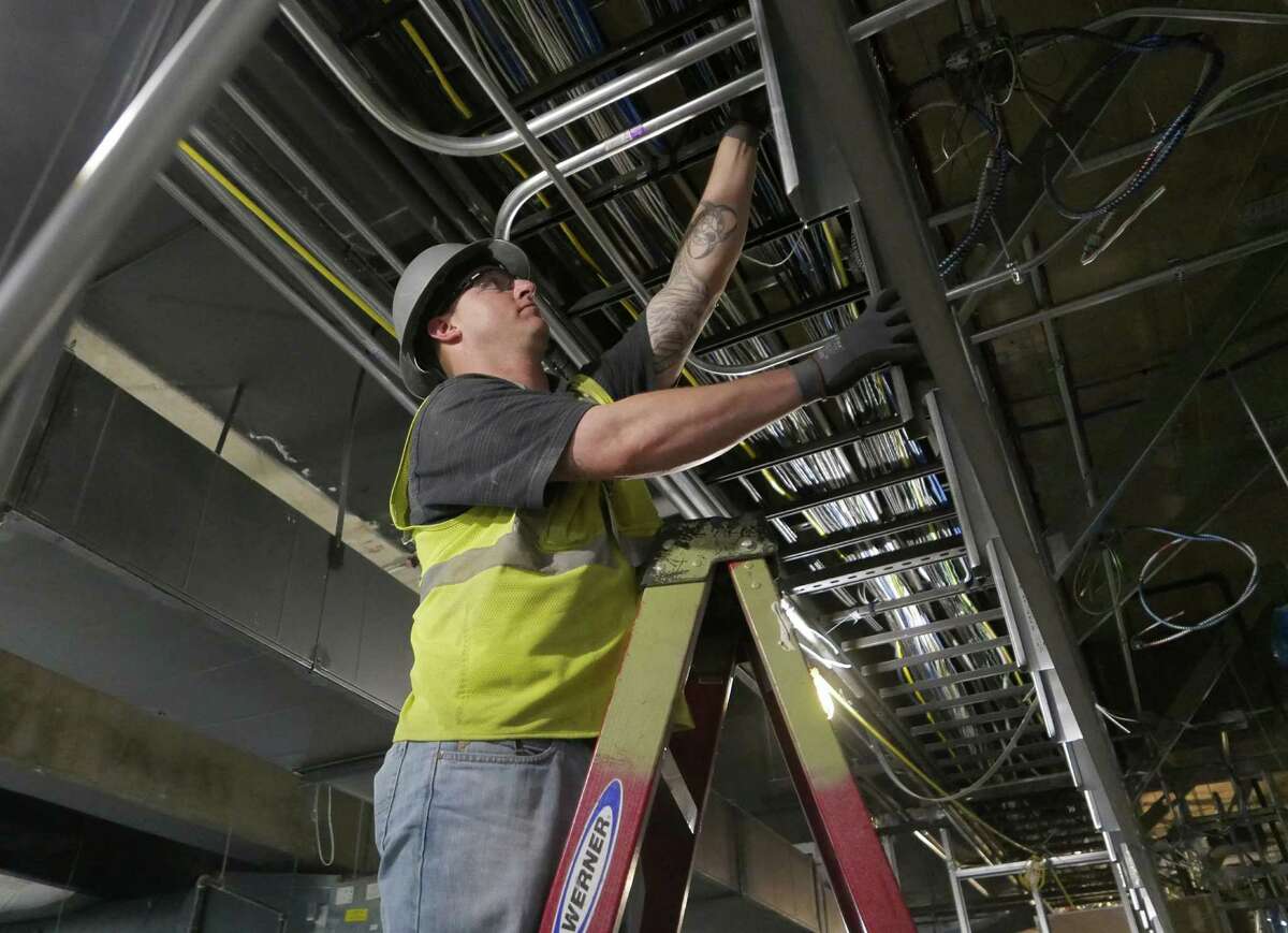 Electrician John Hopper works on cables and conduits at the AT&T Center on Wednesday, Oct. 28, 2015, where renovations are wrapping up ahead of the Spurs home opener on Friday. Hopper, who has a criminal past, got his job at the county-sponsored "Second Chance Job Fair" at the arena earlier this year.