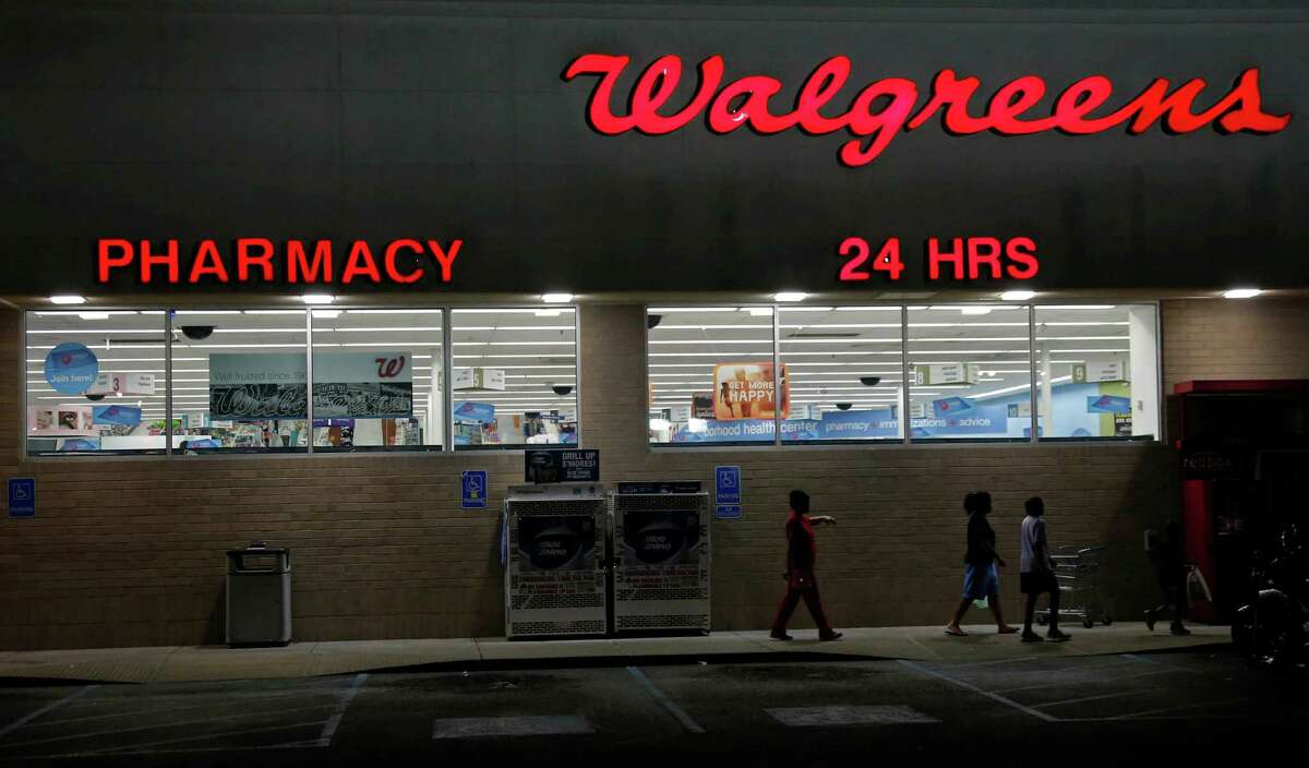 FILE - In this June 21, 2013, file photo, customers leave a Walgreens pharmacy in Jackson, Miss. Walgreens will use its $9.41 billion takeover of rival Rite Aid to spread its philosophy on making drugstores destinations for customers looking to stay healthy or buy beauty products. (AP Photo/Rogelio V. Solis, File)