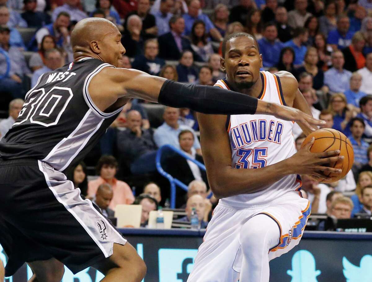 San Antonio Spurs forward David West (30) defends as Oklahoma City Thunder forward Kevin Durant (35) drives to the basket in the second quarter of an NBA basketball game in Oklahoma City, Wednesday, Oct. 28, 2015. (AP Photo/Sue Ogrocki)
