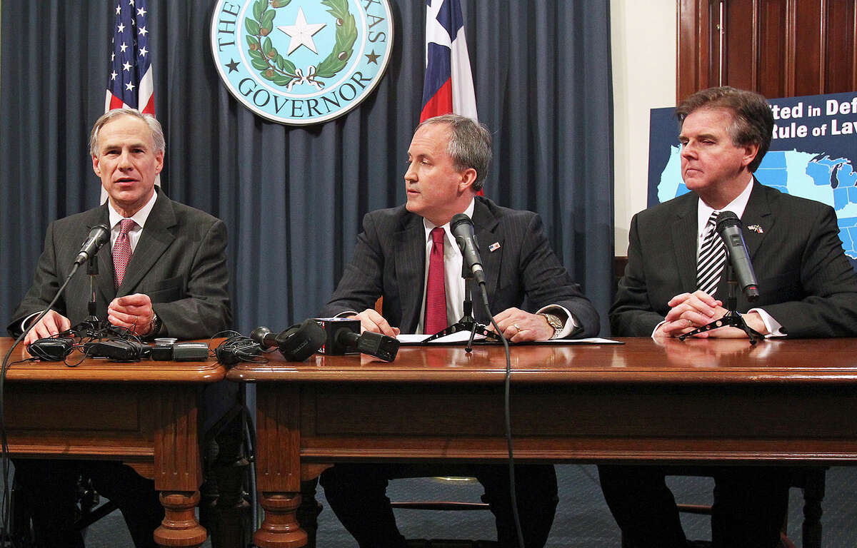 Gov. Greg Abbott, talks to reporters as Attorney General Ken Paxton listens at a news conference at the State Capitol in February. Paxton’s legal woes now include a threat of disbarment because of his actions after the Supreme Court ruled on gay marriage. But if he warrants investigation by the State Bar, why not Abbott, who acted similarly?