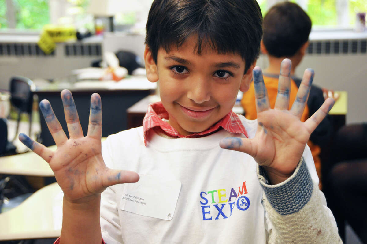 First-grader Rami Rahman shows off his fingerprints in the spy detective and fingerprinting workshop at Stanwich School’s STEAM expo.