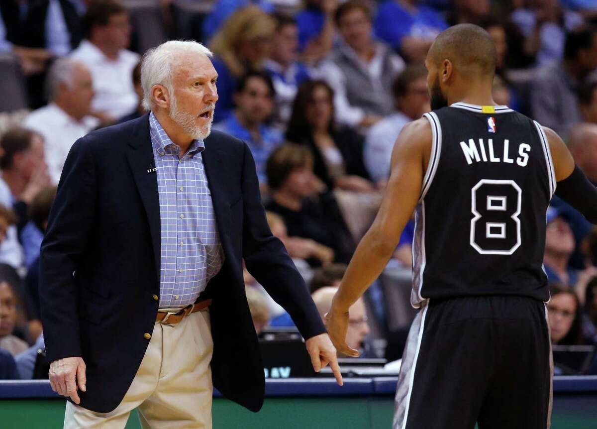 Spurs coach Gregg Popovich talks with guard Patty Mills during the second quarter against the Oklahoma City Thunder.