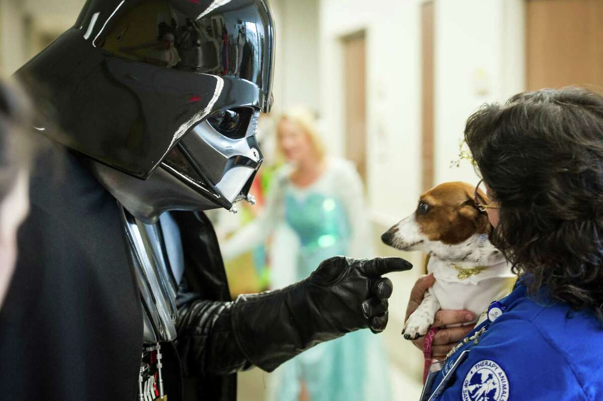 Darth Vader goes to pet a wary Bonnie, held by Melinda Red Cloud, during University Hospital's annual Pediatric Parade in San Antonio on Friday, October 30, 2015. University Hospital's annual Pediatric Parade includes current and former pediatric patients dressed in costumes and trick-or-treating through the hospital's Sky Tower.
