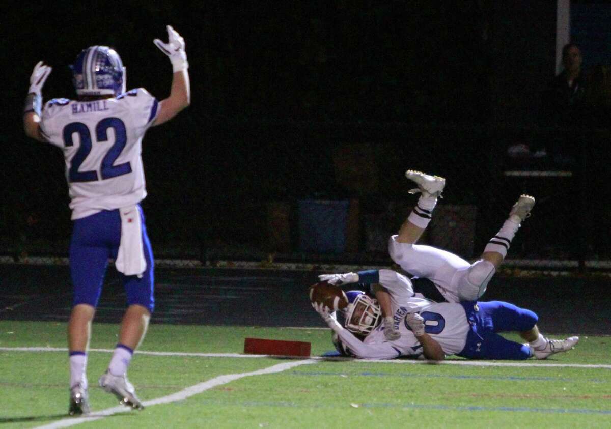 Darien's Hudson Hamill signals touchdown as Colin Minicus stretches in as he is taken down by Wilton's Sam Wright during a varsity football game on Oct. 30, 2015 in Wilton.