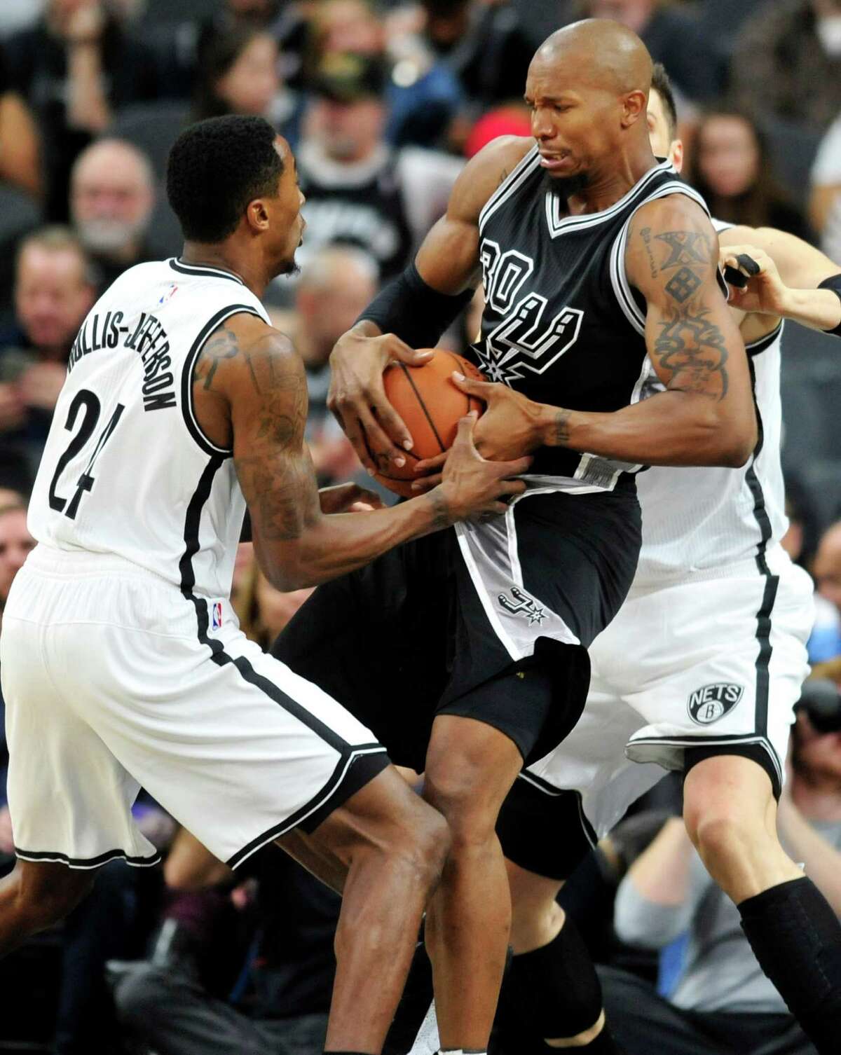Brooklyn Nets forward Rondae Hollis-Jefferson, left, tries to steal the ball from San Antonio Spurs forward David West in the first half of an NBA basketball game Friday, Oct. 30, 2015, in San Antonio. (AP Photo/Bahram Mark Sobhani)