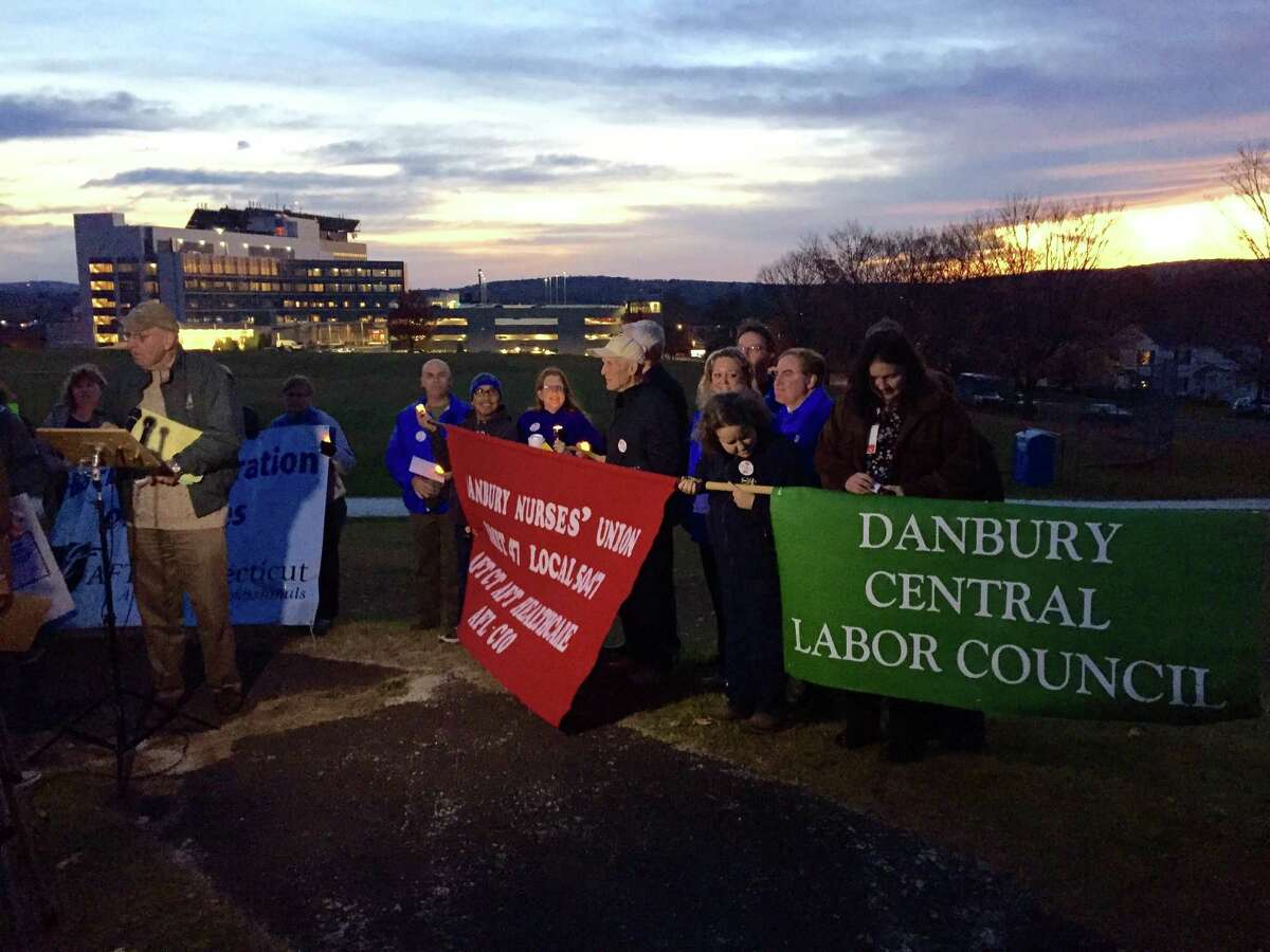 Participants brought banners to the vigil supporting health care workers at Danbury and New Milford hospitals. Danbury Hospital is visible in the background.