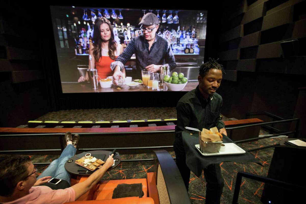 Christian Williams serves food in one of the screening rooms before the start of a movie at iPic Theaters, opening Nov. 6 in Houston.