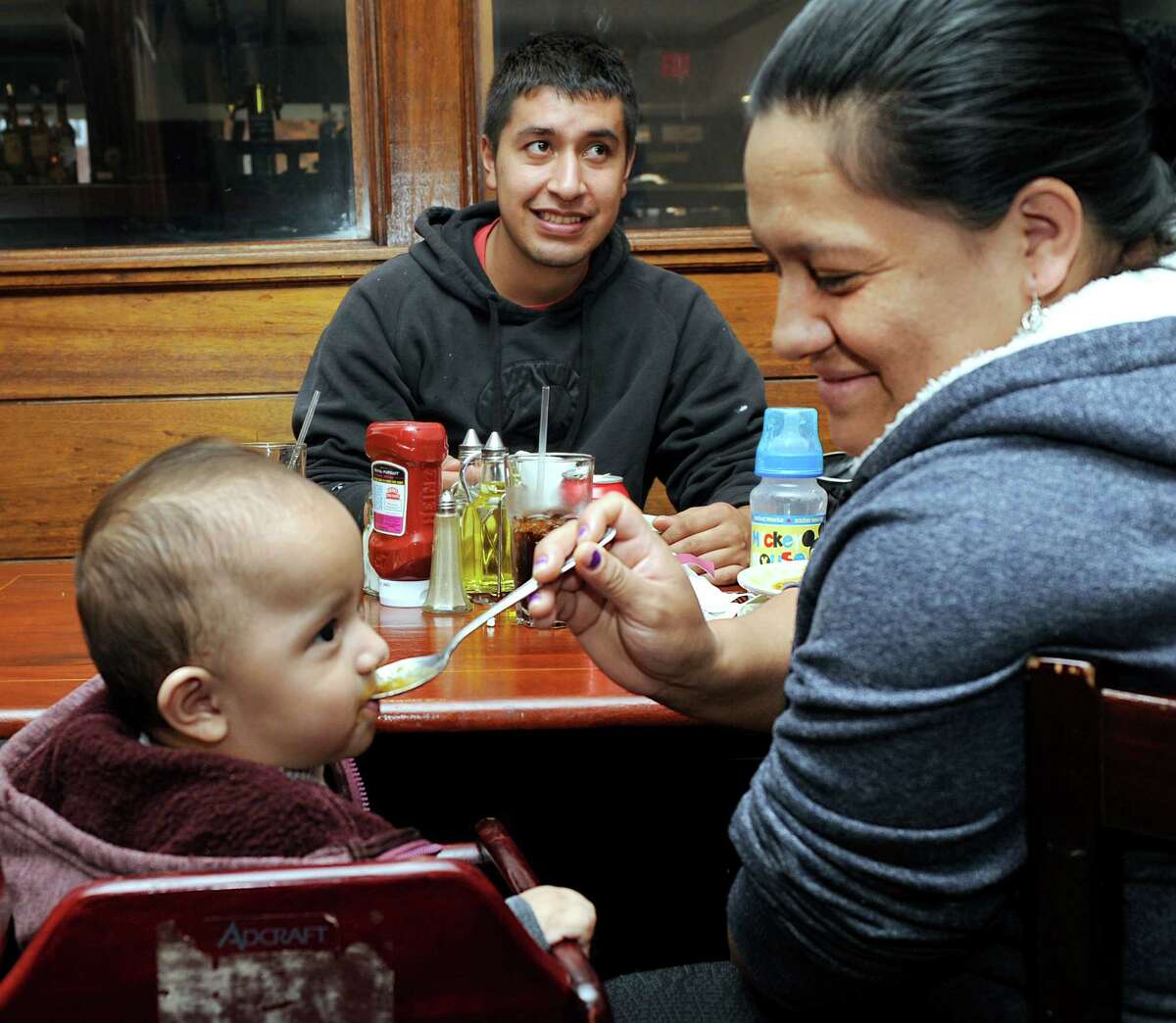 Christian and Alexandra Fajardo have lunch together at Mitad Del Mundo with 7-month-old baby, Jeeryk. Mitad Del Mundo, an Ecuadorian restaurant owned by Wilson Hernandez, recently moved from West Street to 275 Main Street in Danbury, Coon. Photo Monday, Nov. 2, 2015.