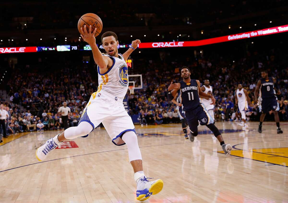 Stephen Curry of the Golden State Warriors saves the ball from going out of bounds then makes a three-point basket over Mike Conley of the Memphis Grizzlies at ORACLE Arena on November 2, 2015 in Oakland, California.