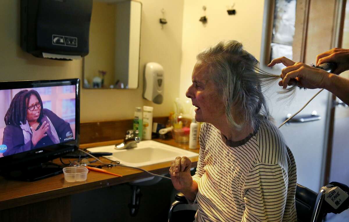Erin Kane, 50, right, does the hair of her mother Helen Kane, 78, who has Alzheimer's at The Rafael assisted living home Nov. 3, 2015 in San Rafael, Calif. Erin took care of her mother Helen for seven years before she had to move her into an assisted living home earlier this year after it became too difficult for Erin to care for Helen on her own. Erin lives only a few miles from the home and is able to visit her mother multiple times a day.