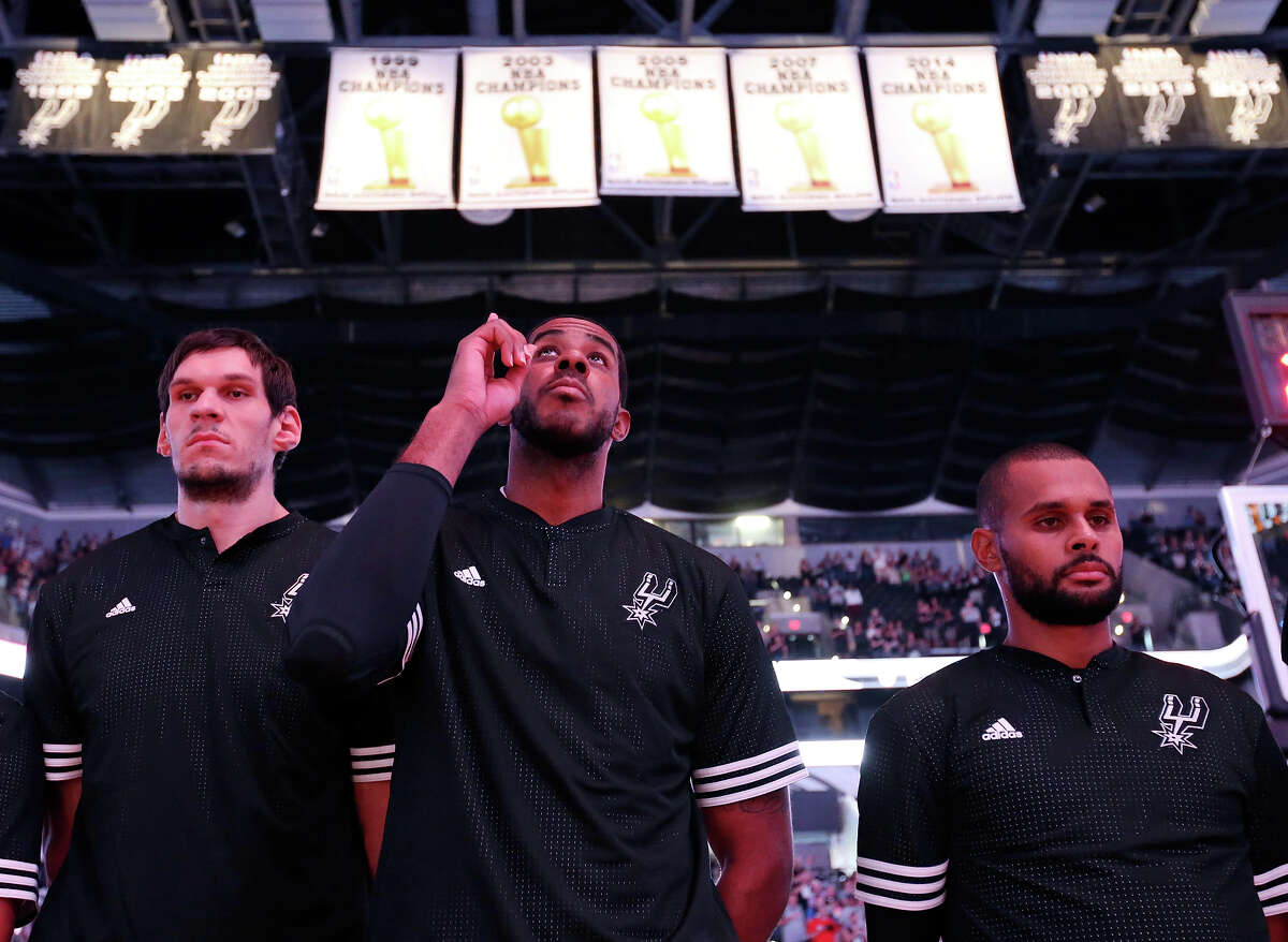 Spurs' Boban Marjanovic (from left), LaMarcus Aldridge, and Patty Mills, stand during the national anthem before the game with the Pistons during first half action Sunday Oct. 18, 2015 at the AT&T Center.