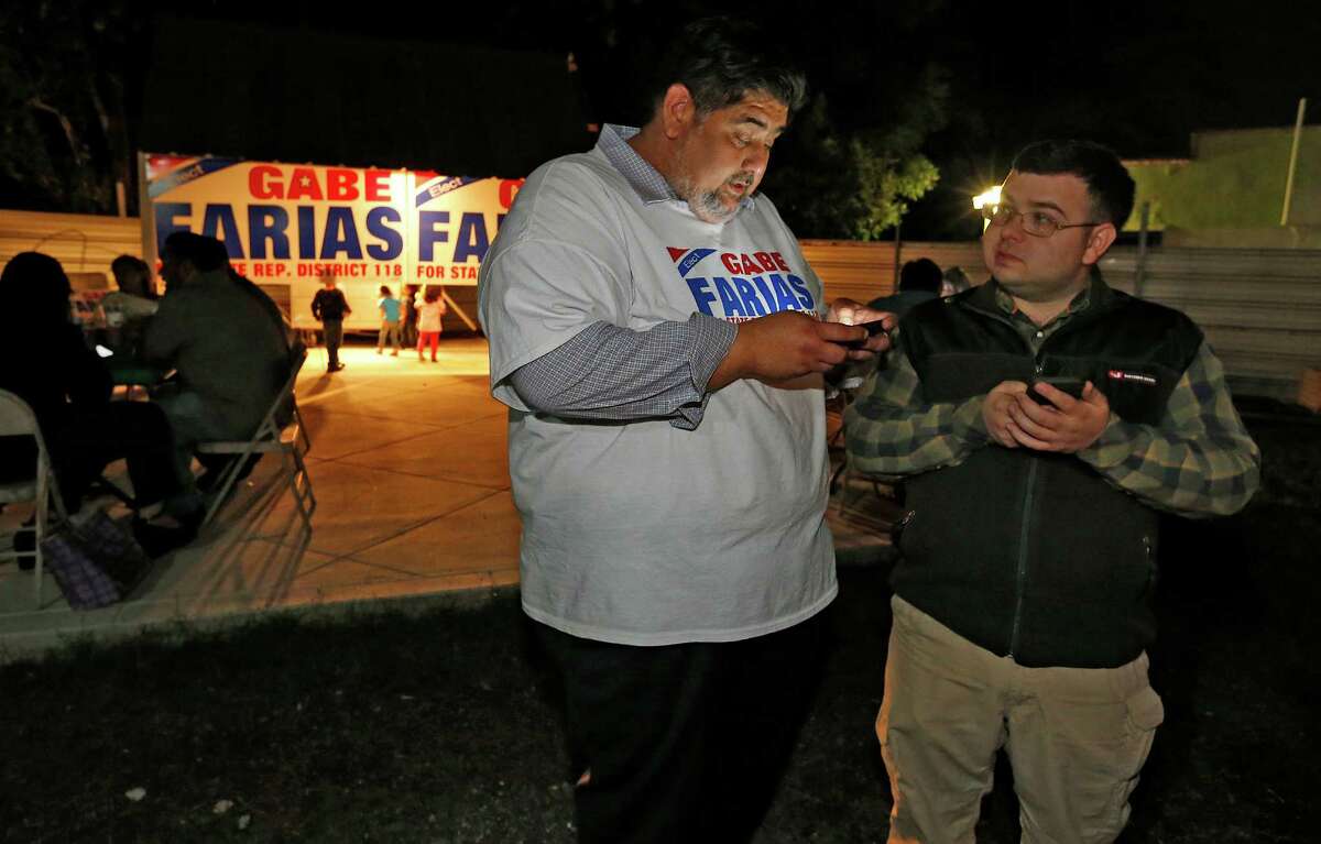 Democrat Gabe Farias (center) and supporter Reid Koenig look for election night results at Farias' campaign party at Southside BBQ. Farias, CEO of the West Side Chamber of Commerce, was among six candidates vying for the District 118 seat.