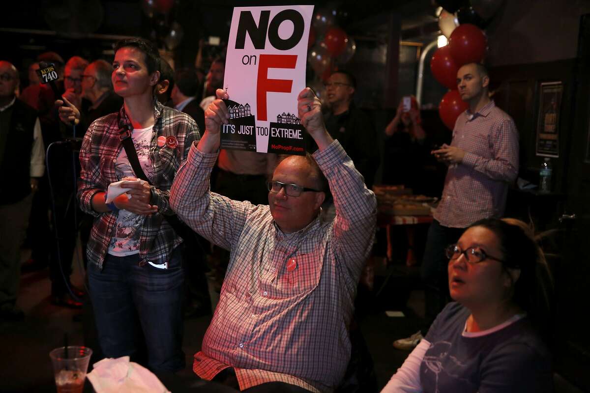 Bruce Bennett holds a "No on F" sign during an election night party at Oasis in San Francisco, California, on Tuesday, Nov. 3, 2015.