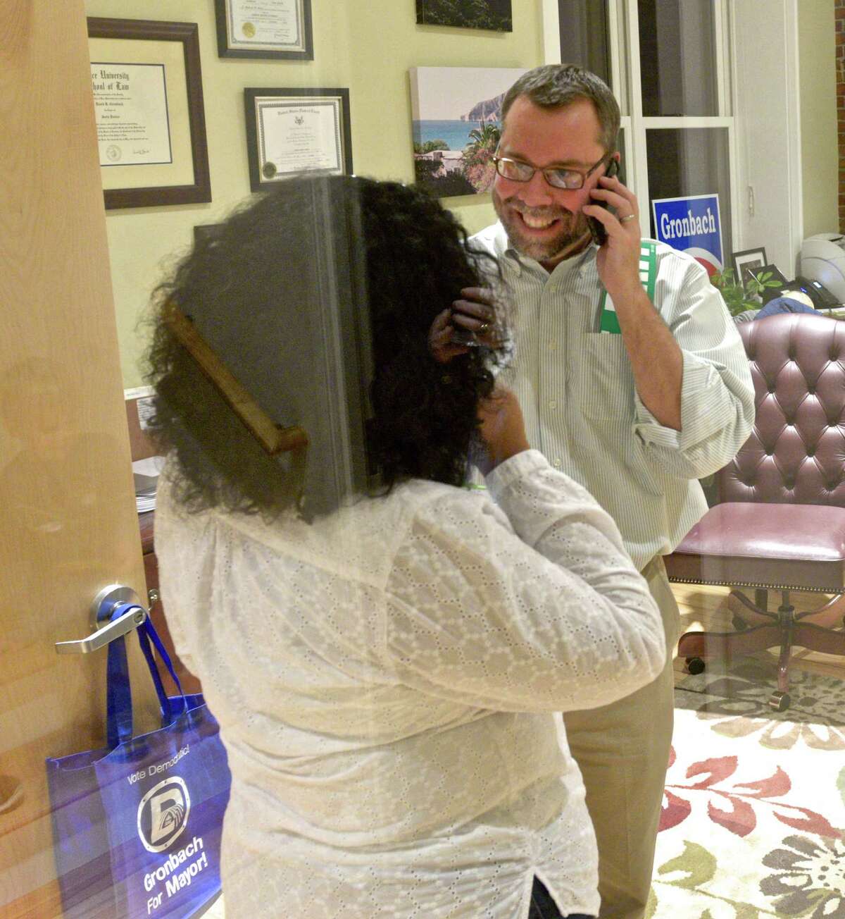 David Gronbach, Democratic candidate for Mayor in New Milford, gets results on the phone as he spends a moment with is wife Vanessa .