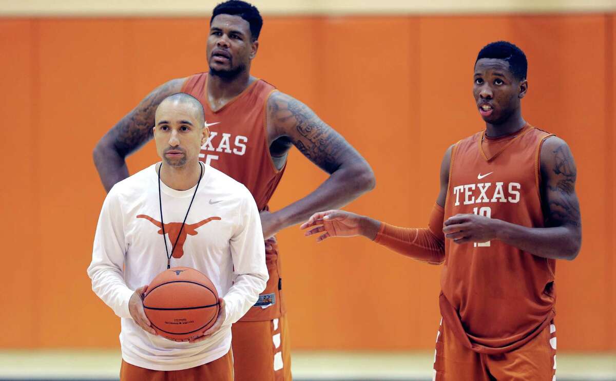 In this Oct. 13, 2015, file photo, Texas head basketball coach Shaka Smart runs drills during a practice at the team's facility as Cameron Ridley (55) and Kerwin Roach, Jr., right, look on, in Austin, Texas. Hired in early April, Smart has had several months to settle into his new environment and size up his roster and he prepares to bring his up-and-down-the-court style to the rugged Big 12.(AP Photo/Eric Gay)