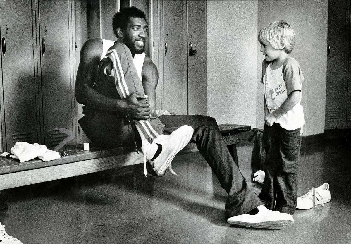 金州勇士队前锋克利福德·雷在更衣室里与里克·巴里的儿子布伦特交谈。1976年9月21日。