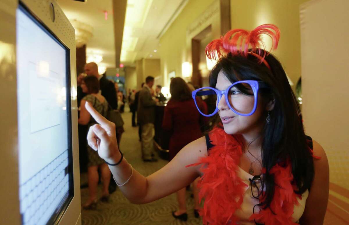 Betsy Cavillo gets ready to take a photo in a photo booth at the Houston Chronicle's annual Top Workplaces event Thursday, Nov. 5, 2015, in Houston.