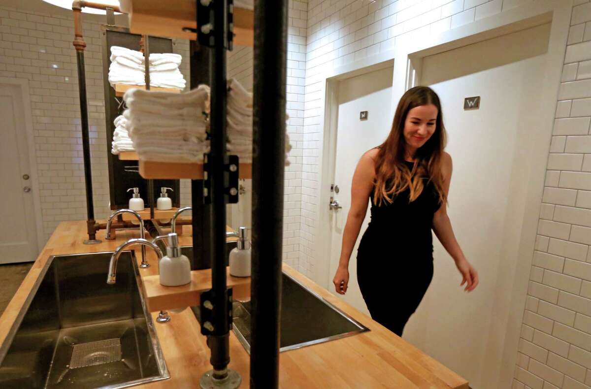 Britany Devlin uses the communal bathroom at The Pass & Provisions restaurant Thursday, Nov. 5, 2015, in Houston, Texas. "To me it wasn't a bathroom ordinance, it was an equal rights ordinance," said Devlin. "I love the bathroom here, it has closed stalls." The doors, marked with a W for women and M for men, lead to a private individual restroom with a communal wash area. ( Gary Coronado / Houston Chronicle )