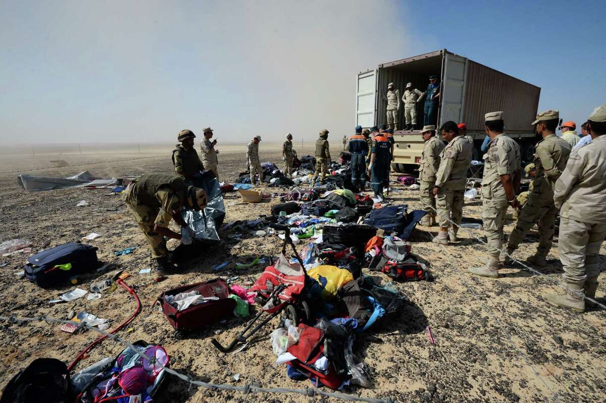 FILE - In this Monday, Nov. 2, 2015 file photo provided by the Russian Ministry for Emergency Situations, Egyptian soldiers collect personal belongings of plane crash victims at the crash site of a passenger plane bound for St. Petersburg in Russia that crashed in Hassana, Egypt's Sinai Peninsula. If an Islamic State bomb caused the Russian plane crash in Egypt, as U.S. and British officials suggest, it would mark the extremist group's largest act of transnational terrorism by far, and could herald a new phase in its conflict with much of the world. (Russian Ministry for Emergency Situations via AP, File) ORG XMIT: CAIMA301