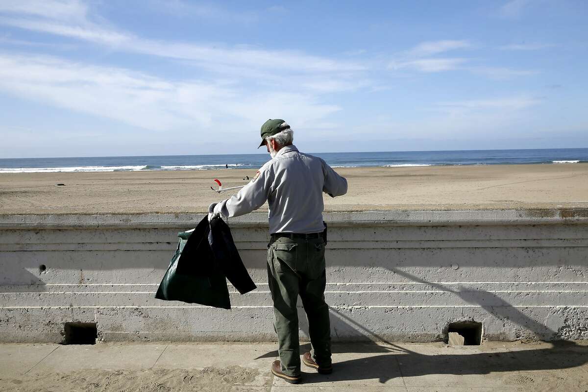 Maintenance worker James Brown picks up trash at Ocean Beach in San Francisco, California, on Thursday, Nov. 5, 2015.