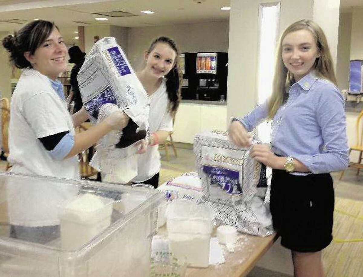 Lexi Kelley, center, the founder of Kids Helping Kids in Stamford, is shown in this file photo during the organization’s annual bread bake fundraiser. Kelley is in college this year, but the event will continue on.