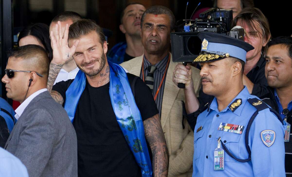 Former England international football player and UNICEF Goodwill Ambassador David Beckham (2L) getures as he arrives at the start of a visit to Nepal for the United Nations Childrens Fund (UNICEF) in Kathmandu on November 6, 2015. Beckham is scheduled to take part in documentary and play in a charity football match. AFP PHOTO / Rajendra KCRajendra KC/AFP/Getty Images