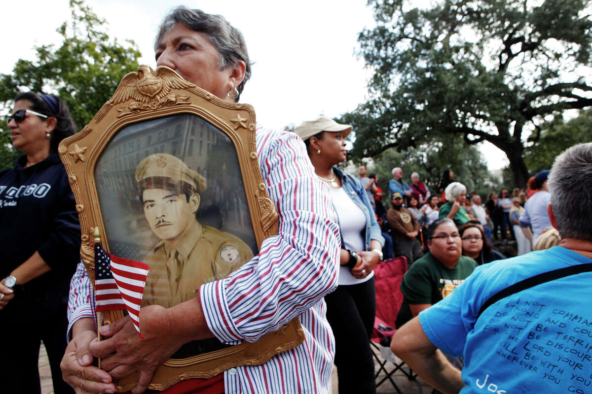Rosie Soto Diaz holds a photo of her father, Antonio R. Soto, while watching the 2013 Veterans Parade. Her father would tell her stories about the war, she said