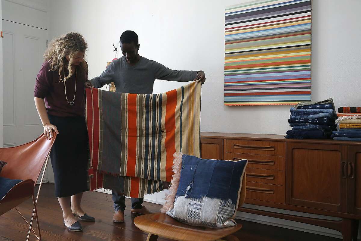 Petel founders Julie Wagne (left) and her husband Ibrahima Wagne (middle) show his great grandmother's blanket at home in San Francisco, Calif., on Friday, November 6, 2015.
