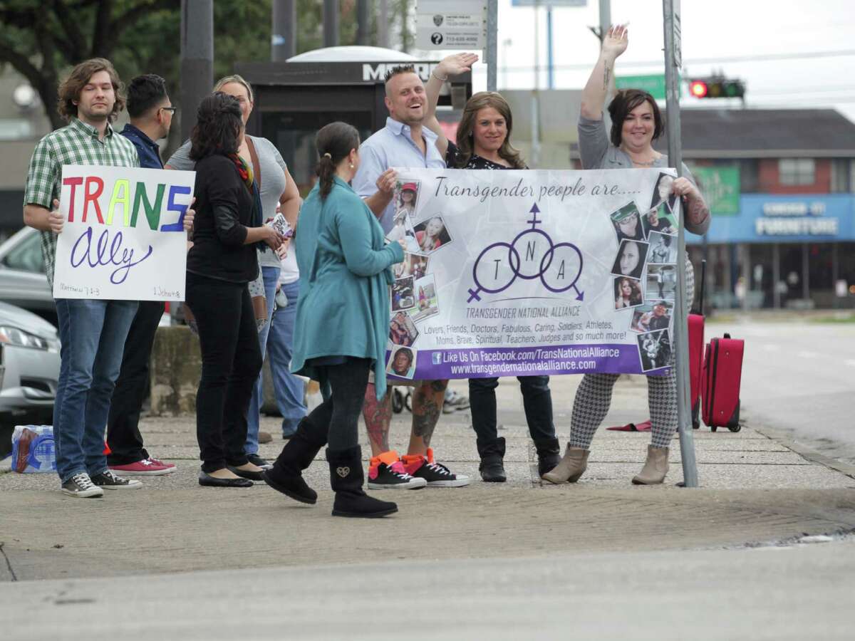 People wave to traffic at a rally Saturday for awareness of the transgender community﻿ at the corner of Montrose Boulevard and Westheimer Road﻿.