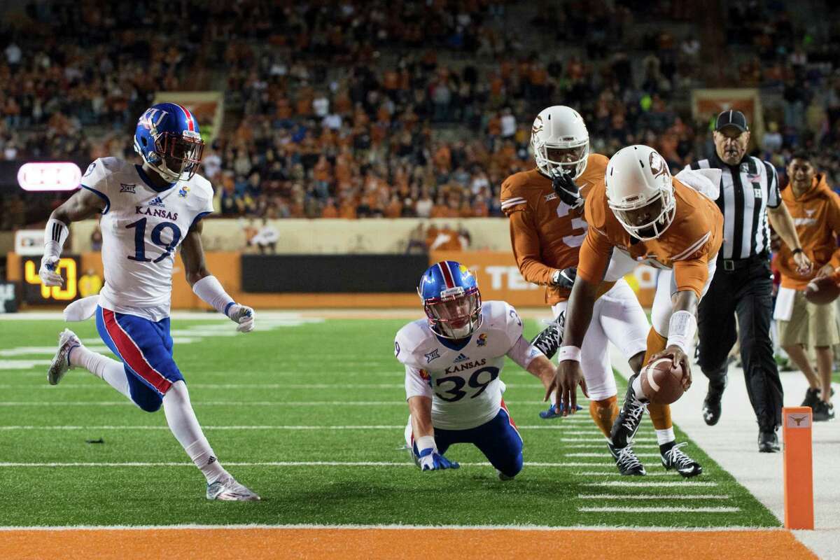 Texas quarterback Tyrone Swoopes finishes an unusual play by diving into the end zone after scooping up a fumble by Kirk Johnson.