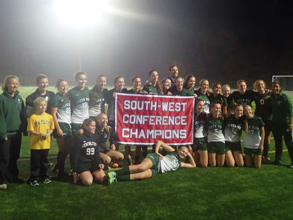 The New Milford High School girls soccer team celebrates with its championship banner after defeating Immaculate on penalty kicks in the SWC title match on Nov. 5, 2015, at Newtown High School.