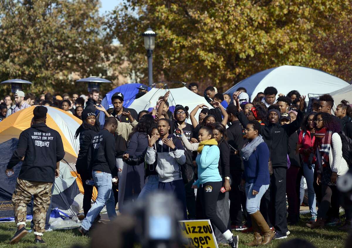 CORRECTS WITH NEW CAPTION - University of Missouri students celebrate as Jonathan Butler, center, waving, ended his hunger strike Monday, Nov. 9, 2015, now that University of Missouri System President Tim Wolfe has officially resigned, in Columbia, Mo. Wolfe has been under fire for his handling of race complaints that had threatened to upend the football season and moved Butler to go on a hunger strike. (Justin L. Stewart/Columbia Missourian via AP)