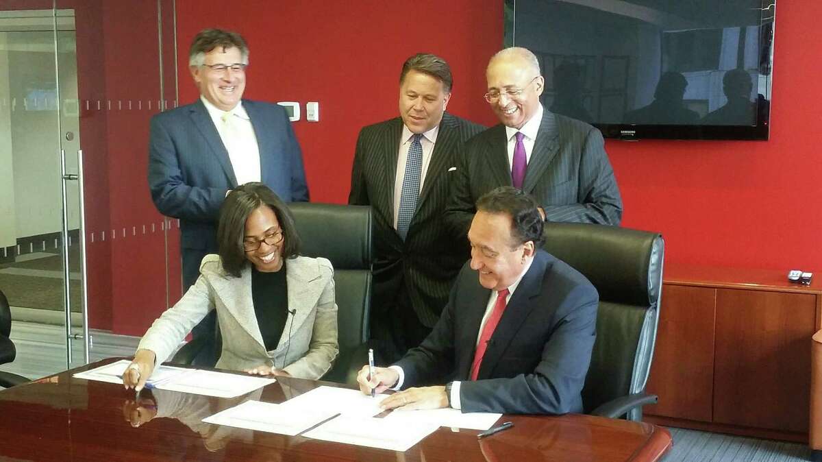 Former San Antonio Mayor Henry Cisneros signs the documents Monday to become part-owner of bond financing firm Siebert Brandford Shank & Co. at the company’s New York office. LLC. Cisneros’ business partner Victor Miramontes of San Antonio (standing left) also became a part owner Monday. Also shown are Siebert Brandford Shank Chairwoman and CEO Suzanne Shank; Sean Duffy (center), managing director of institutional sales; and William Thompson, chief administrative officer and managing director.