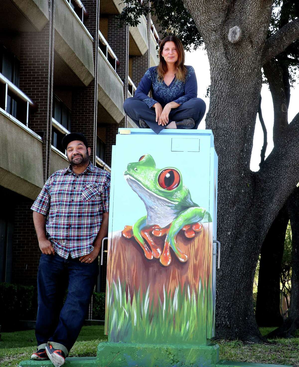 Studio owner Noah Quiles, left, and artist Anat Ronen check out the second mural Ronen created on a utility box in the Westchase District after the first was painted over by a graffiti abatement worker.﻿