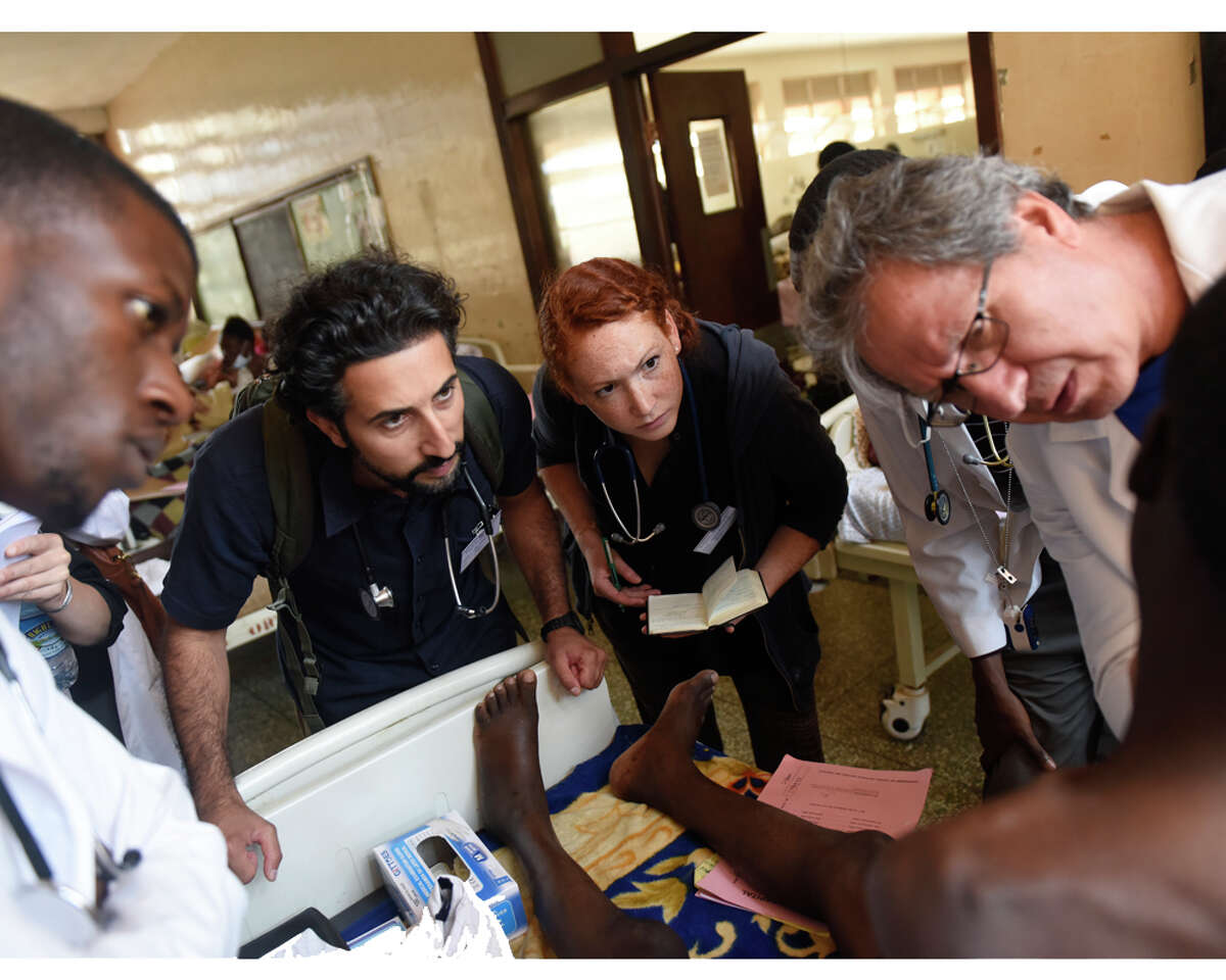 From left, Dr. Brian Beesiga, Dr. Sohi Ashraf, of Norwalk, Conn., University of Vermont first-year medical student Mary-Kate LoPiccolo, of Newtown, Conn., and Danbury Hospital Global Health Department Director Dr. Majid Sadigh examine a patient during clinical rounds at Mulago Hospital in the capital city of Kampala, Uganda Saturday, July 25, 2015.
