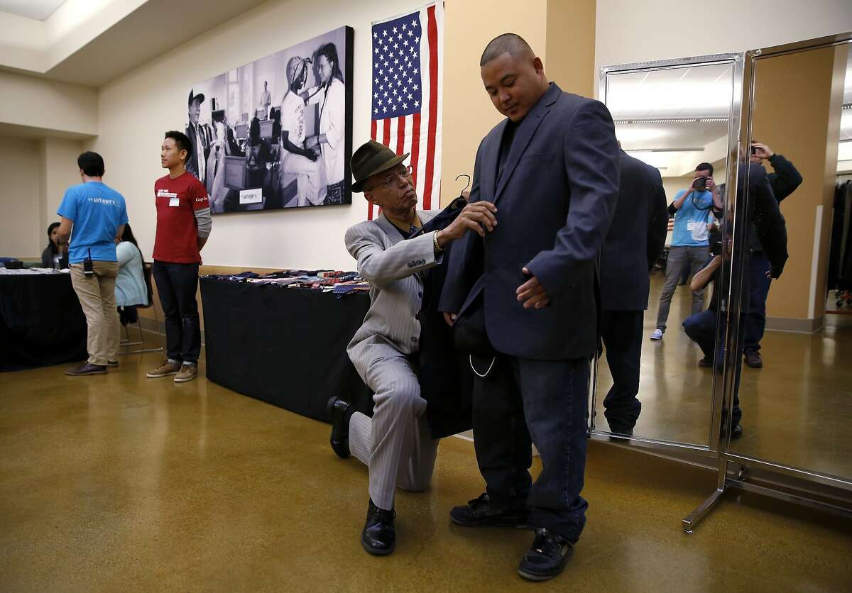 Del Seymour adjusts Mixon Matignas' new jacket during an event to help veterans at the St. Anthony Foundation in San Francisco, California, on Tuesday, Nov. 10, 2015.