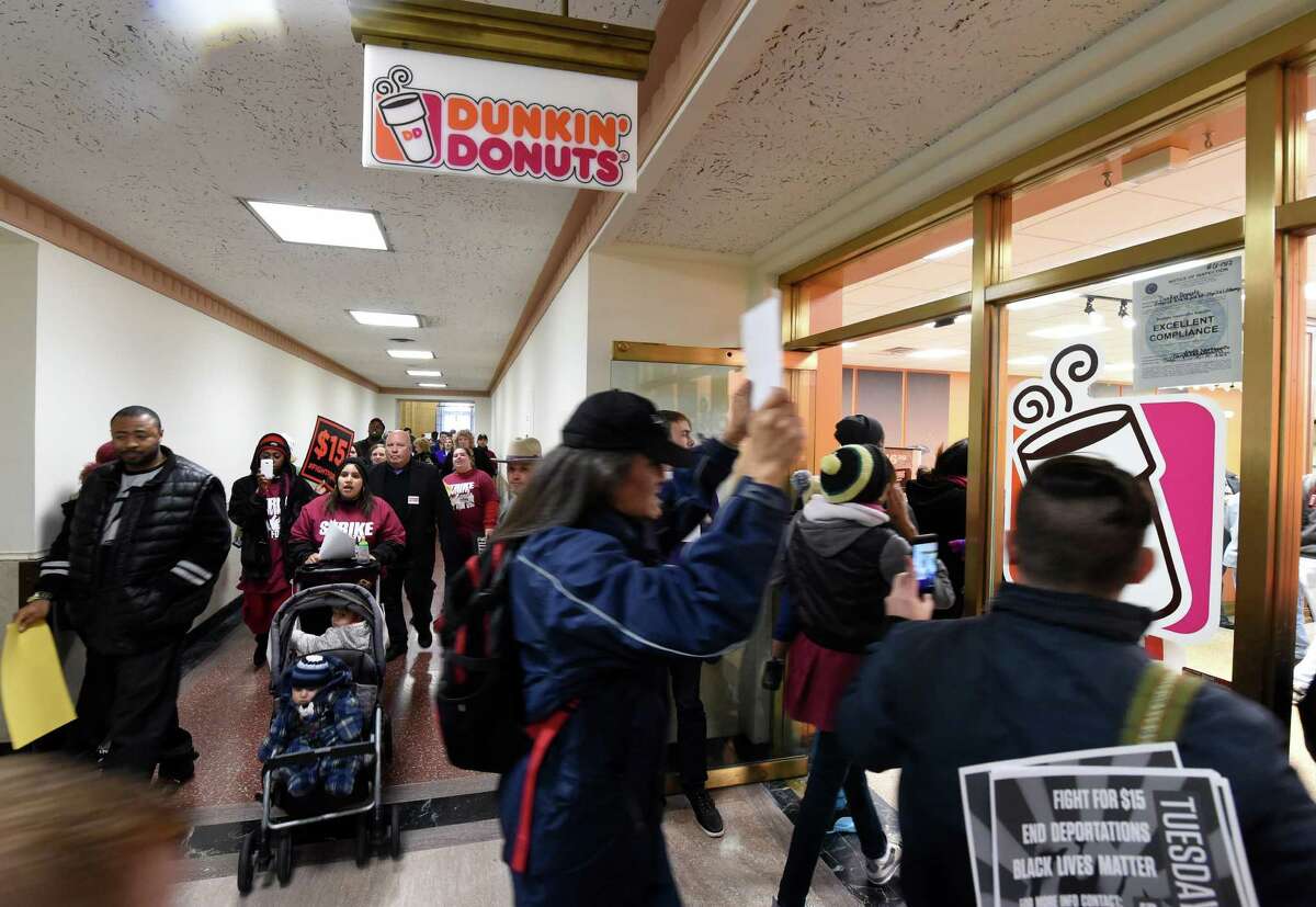 Minimum wage demonstrators march through the Dunkin Donuts store in the State Capitol Tuesday morning Nov. 10, 2015 in Albany, N.Y. (Skip Dickstein/Times Union)