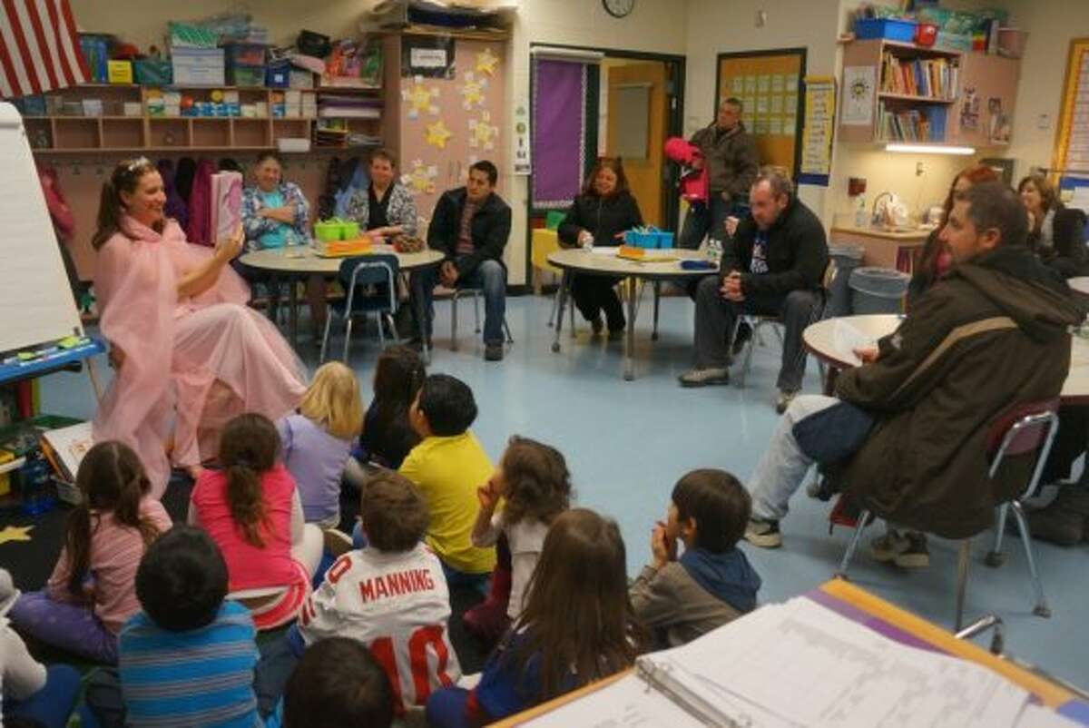 New Lebanon School first-grade teacher Amy Rose reads to students, while their parents watch, at the school's Literacy Night in January.