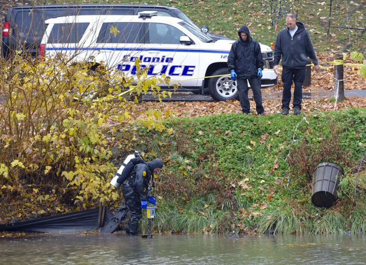 A police diver returned to the pond in Albany's Washington Park on Wednesday to resume the search for the knife investigators said they believe was used to kill Jacquelyn Porreca, a master barber, during an Aug. 21 at the Sand Creek Road salon where she worked. (Skip Dickstein / Times Union)
