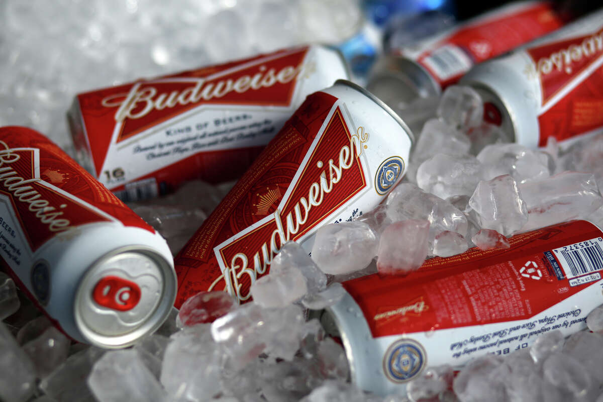 FILE - In this Thursday, March 5, 2015, file photo, Budweiser beer cans are seen at a concession stand at McKechnie Field in Bradenton, Fla. The world's two biggest beer makers will join forces to create a company that produces almost a third of the world's beer, as Budweiser maker AB InBev announced Wednesday, Nov. 11, 2015, a final agreement to buy SABMiller for 71 billion pounds ($107 billion). But in the U.S., the deal will not bring arch rivals Budweiser and Miller under the same roof. (AP Photo/Gene J. Puskar, File)