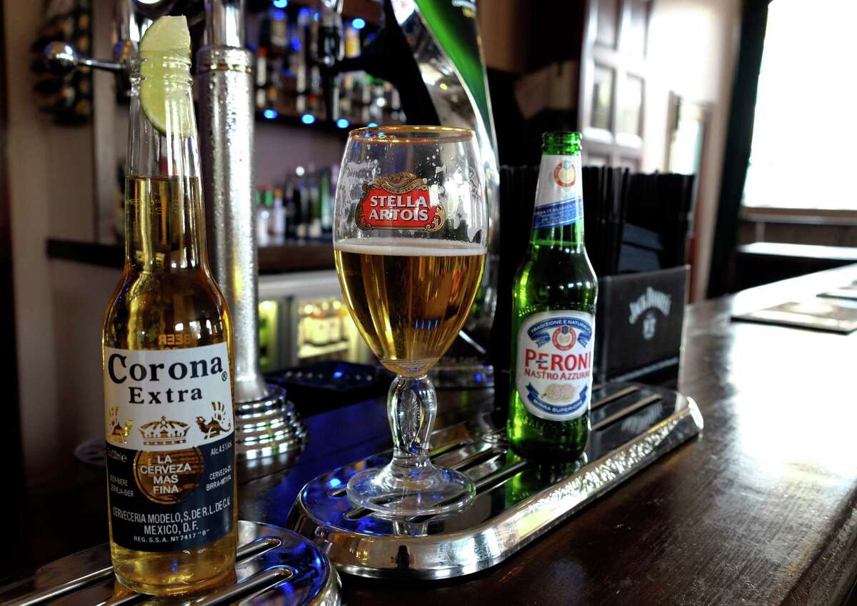 FILE - In this Tuesday, Oct. 13, 2015, file photo, drinks sit on the bar in a pub in London. The world's two biggest beer makers will join forces to create a company that produces almost a third of the world's beer, as Budweiser maker AB InBev announced Wednesday, Nov. 11, 2015, a final agreement to buy SABMiller for 71 billion pounds ($107 billion). But in the U.S., the deal will not bring arch rivals Budweiser and Miller under the same roof. AB InBev's brands include Budweiser, Stella Artois and Corona, while SABMiller produces Peroni and Grolsch. (AP Photo/Kirsty Wigglesworth, File)