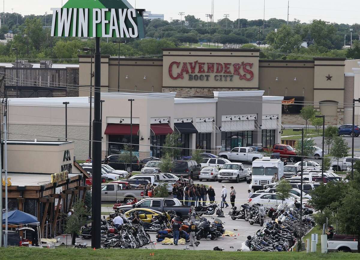 In this May 17, 2015 file photo, authorities investigate a shooting in the parking lot of Twin Peaks restaurant in Waco, Texas. The family of a biker slain in a shootout outside the Waco restaurant has sued the restaurant's parent company alleging negligence, according to a lawsuit filed Wednesday, July 8, 2015, in Dallas County. (AP Photo/Jerry Larson, File)