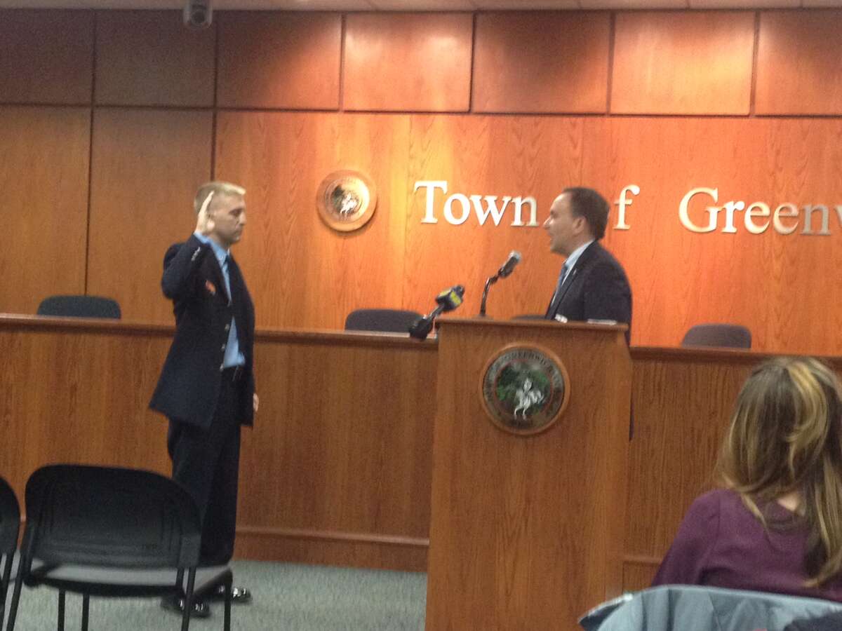First Selectman Peter Tesei delivers the oath of office to Lt. Erik Maziarz at Town Hall.