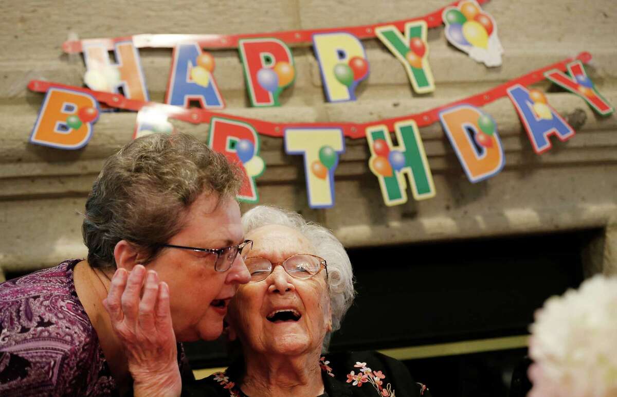 Hilda Matson (center) receives a congratulatory hug from Barbara Goss during Matson's 106th birthday celebration at the Inn at Los Patios senior living community on Thursday, Nov. 12, 2015. Matson was joined by her granddaughter Mary Matson-Even, grandson-in-law Matt Even and a roomful of friends from the community. According to the Census Bureau of the U.S. Department of Commerce, women make up 81-percent of people over the age of 100. Overall, centenarians like Matson, are in an exclusive group which make up about 0.001 percent of the population according to data gathered from the 2010 Census. (Kin Man Hui/San Antonio Express-News)