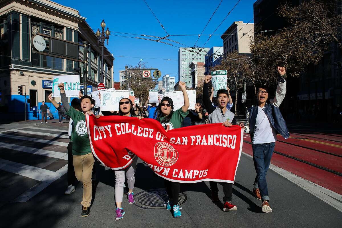 (l-r) Gary Liang, Esther Wu, Jenny Chen, Dan Zhang, and Zhen Ye Pan, all CCSF students, march down Market Street in protest of the anticipated budget cuts at CCSF, in San Francisco, California on Thursday, November 12, 2015.