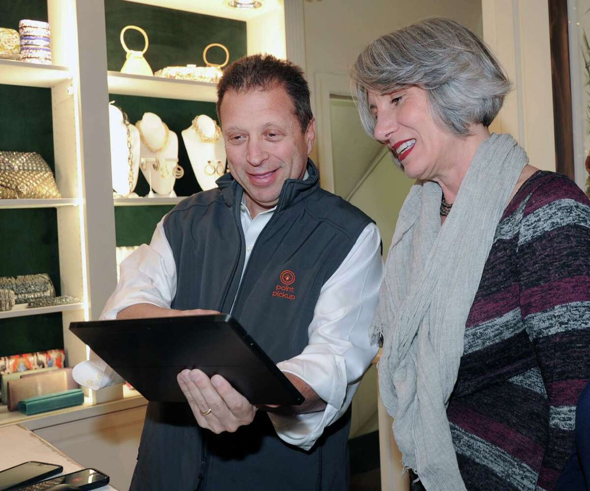 Tom Fiorita,, founder and CEO of Point Pick-Up Technologies, shows his company's app to Bernadette LaMedica, a sales associate for Hoagland's of Greenwich.