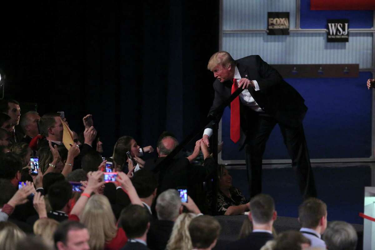 Donald Trump shakes hands with people in the crowd after the Republican presidential debate in Milwaukee, Nov. 10, 2015. A reader says the media panel missed a chance to ask some crucial questions about his immigration proposals.